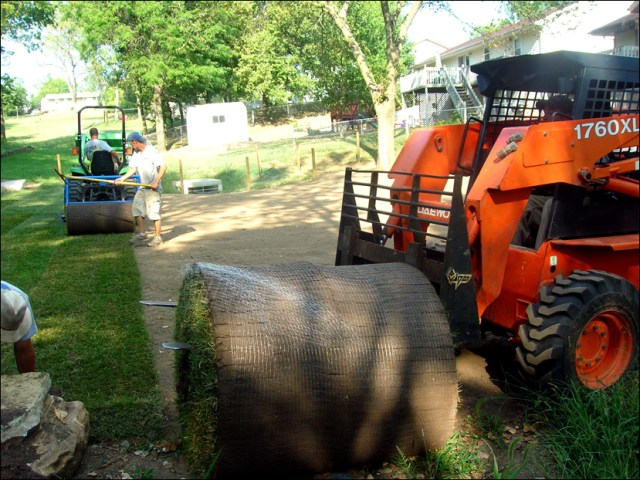 Sod_Laying_in_Kansas Skid loader laying sod roll in Kansas